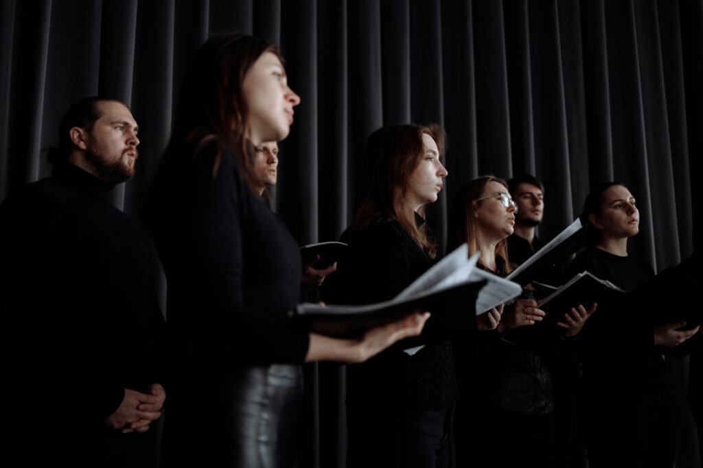 choir in black holding music sheets